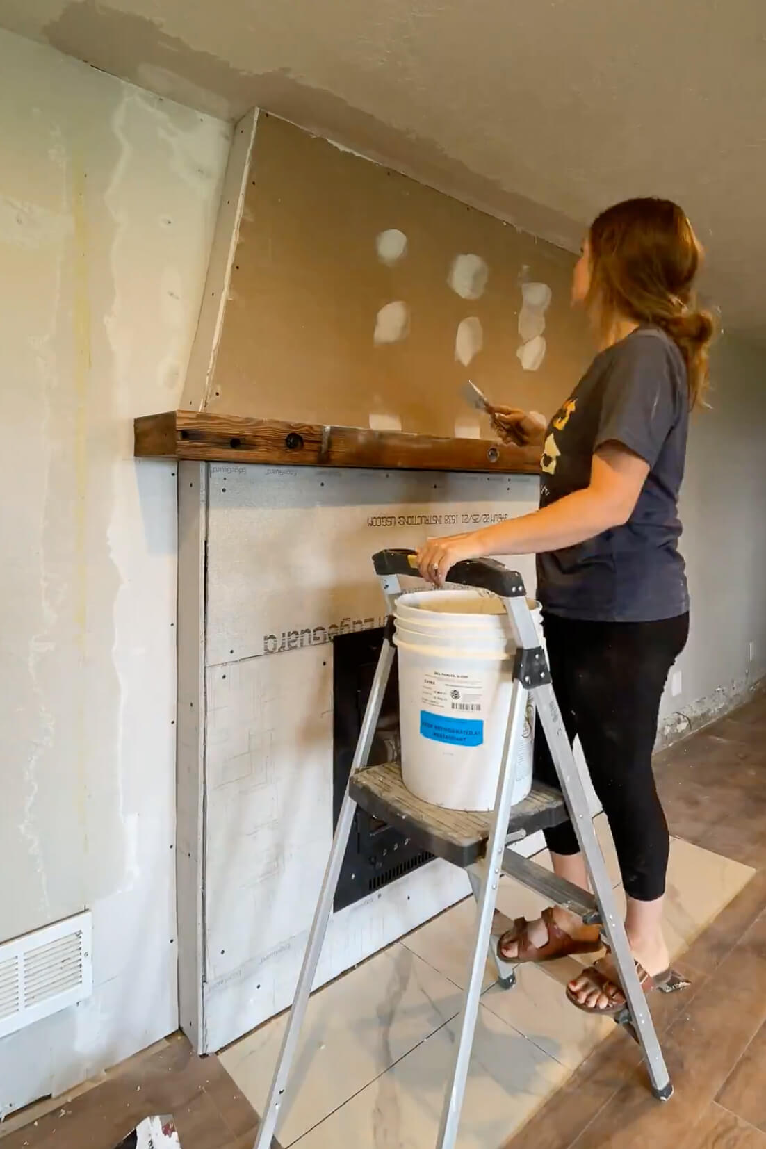 Finishing drywall around a fireplace.